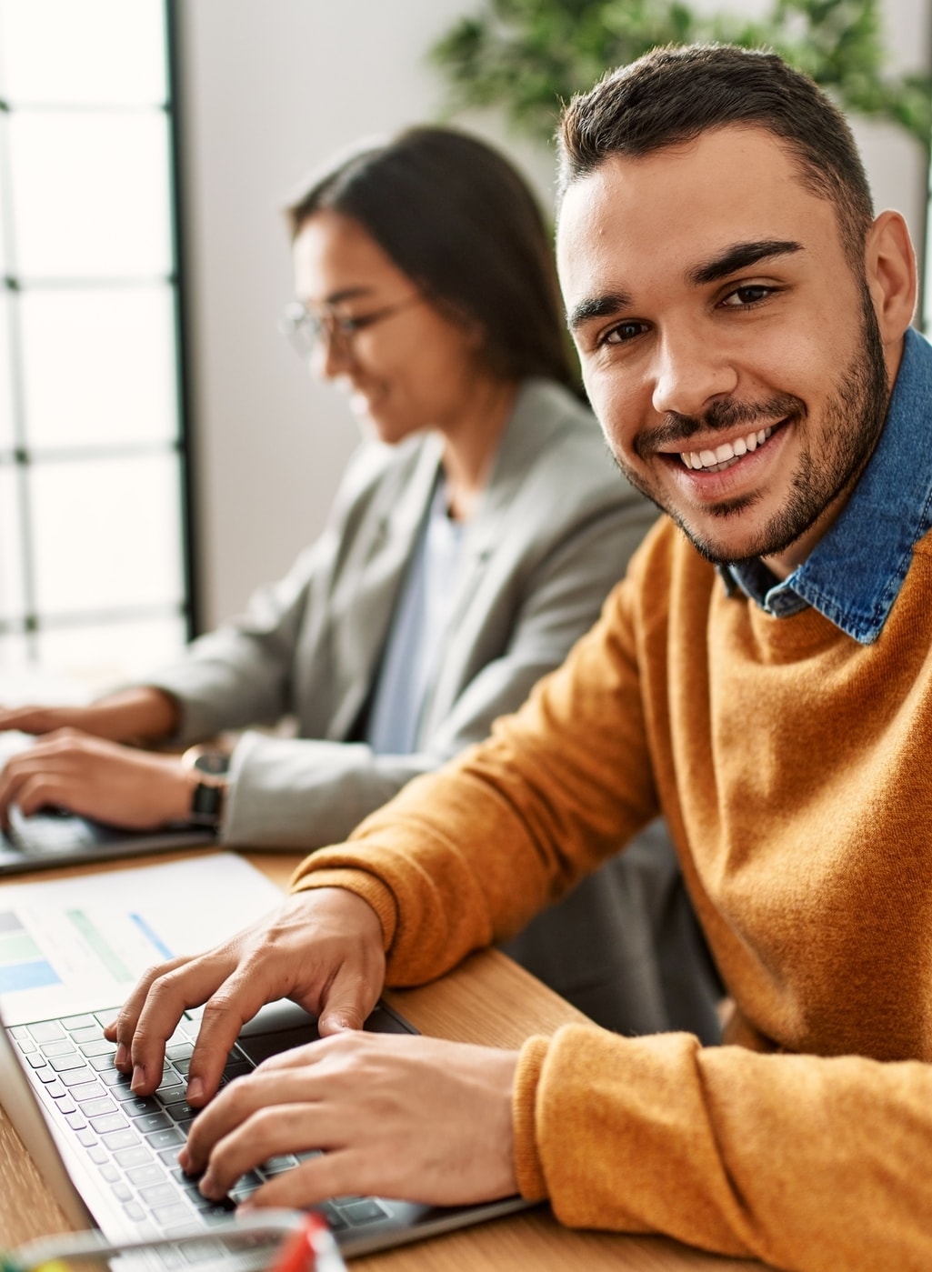 Mitarbeitende im Büro arbeiten konzentriert und zufrieden an Laptops – Symbol für Produktivität und stabile Teams